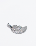 Load image into Gallery viewer, A silver-toned wing pendant encrusted with clear pavé stones,
