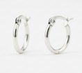 Load image into Gallery viewer, Pair of silver hoop earrings on white background
